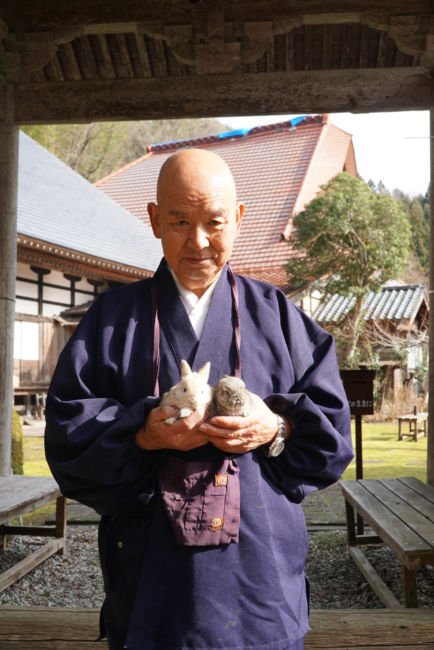 monk with pet rabbits