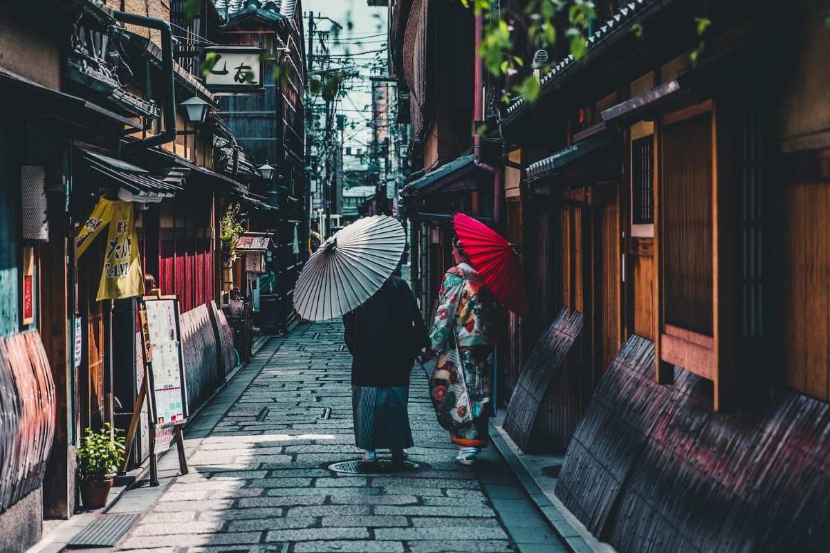 people in traditional clothes walking in japanese street